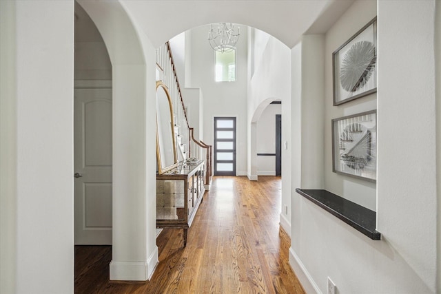 entrance foyer featuring baseboards, wood finished floors, and stairs