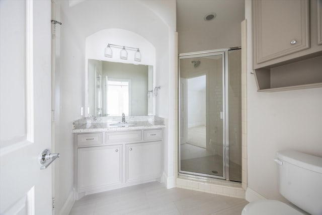 full bath with vanity, toilet, a stall shower, and baseboards