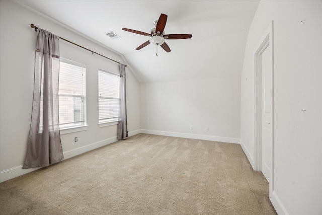 interior space with light carpet, visible vents, baseboards, lofted ceiling, and a ceiling fan