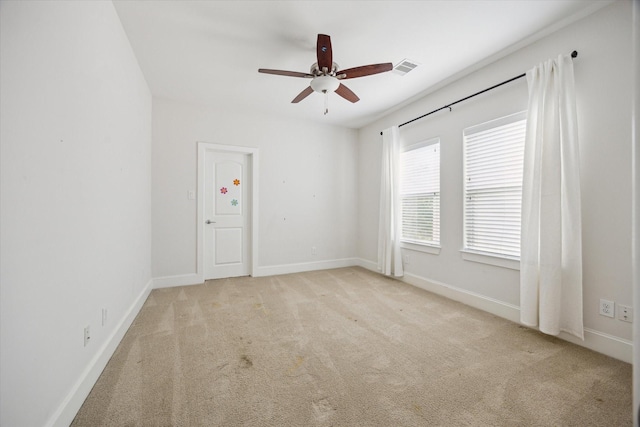 unfurnished room featuring visible vents, baseboards, carpet flooring, and ceiling fan