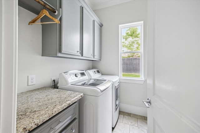 laundry area featuring cabinet space, washing machine and dryer, a wealth of natural light, and baseboards