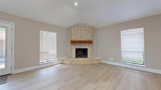 7126 Rio Blanco Dr, Houston, TX 77083 - unfurnished living room featuring vaulted ceiling, a brick fireplace, wood finished floors, and baseboards