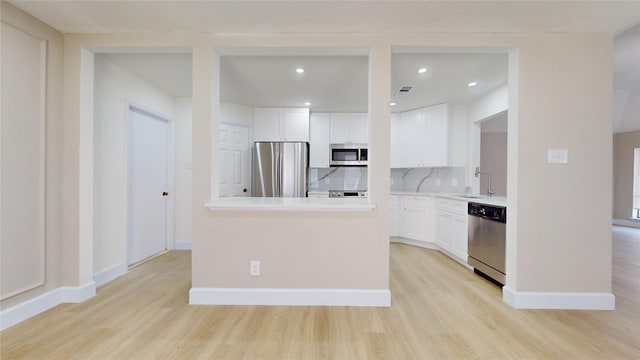 7126 Rio Blanco Dr, Houston, TX 77083 - kitchen featuring appliances with stainless steel finishes, a sink, white cabinetry, and light wood-type flooring