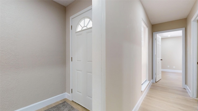 7126 Rio Blanco Dr, Houston, TX 77083 - entrance foyer featuring a textured wall, light wood-style flooring, and baseboards