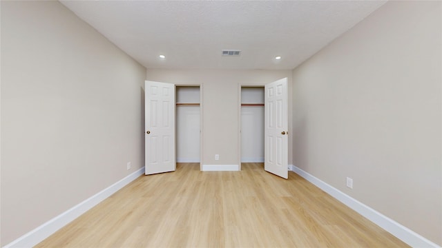 7126 Rio Blanco Dr, Houston, TX 77083 - unfurnished bedroom featuring recessed lighting, two closets, visible vents, and light wood-type flooring