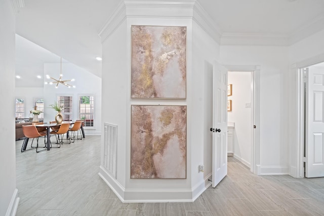 interior space with an inviting chandelier, crown molding, visible vents, and baseboards