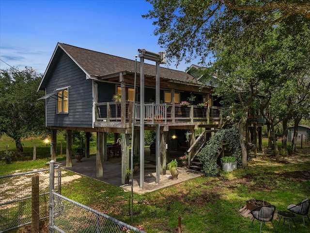 rear view of property featuring a fire pit, fence, stairs, and roof with shingles