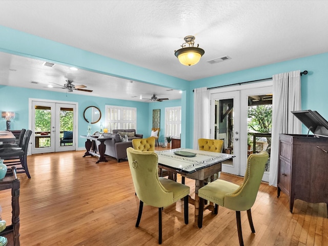939 17th St, San Leon, TX 77539 - dining space with french doors, light wood-style floors, plenty of natural light, ceiling fan, and a textured ceiling