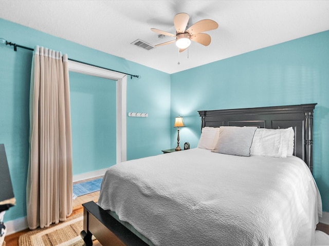 bedroom with wood finished floors, visible vents, ceiling fan, and baseboards