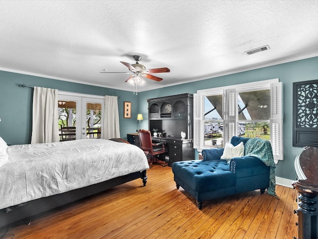 bedroom featuring hardwood / wood-style floors, visible vents, access to exterior, and multiple windows