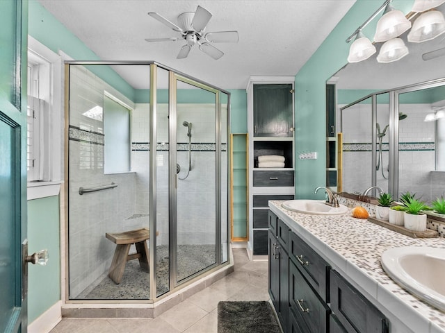 bathroom featuring a stall shower, ceiling fan, and a sink