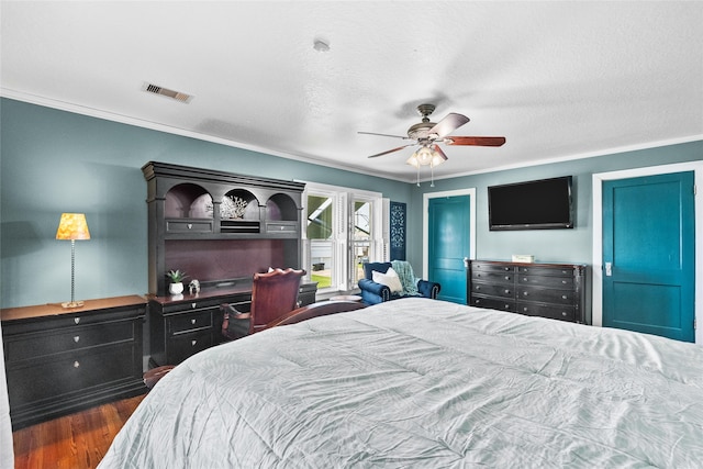 bedroom with visible vents, ornamental molding, ceiling fan, and wood finished floors