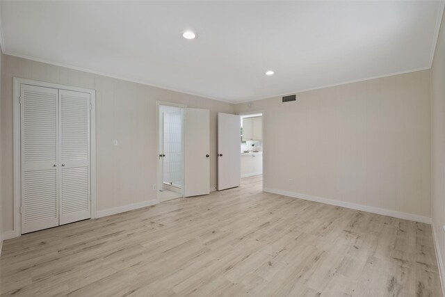 unfurnished bedroom featuring crown molding, baseboards, visible vents, and light wood-style flooring