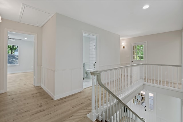 hall featuring light wood-type flooring, attic access, recessed lighting, and an upstairs landing