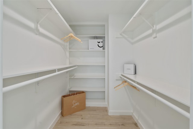 walk in closet with wood finished floors