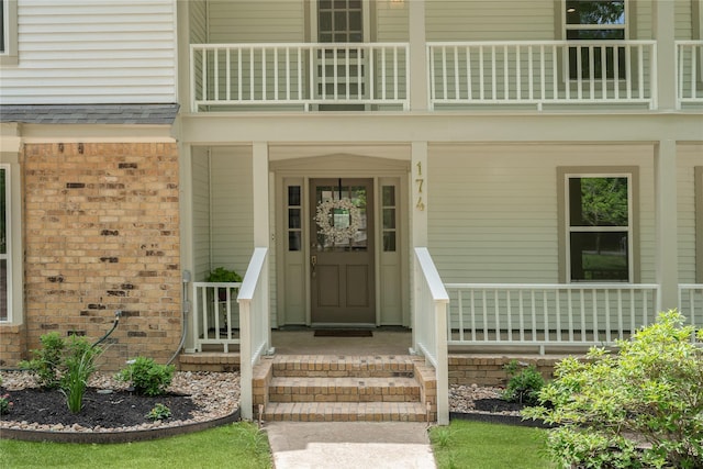 entrance to property featuring brick siding and a balcony