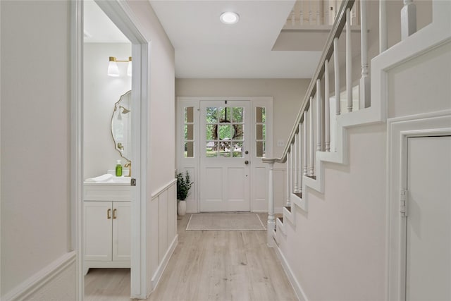 doorway to outside featuring recessed lighting, light wood finished floors, and stairs