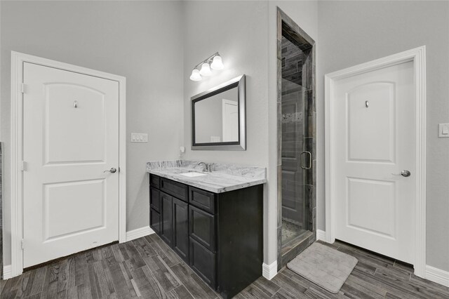 14315 Pecos Ln, Baytown, TX 77523 - bathroom with wood finished floors, a stall shower, vanity, and baseboards