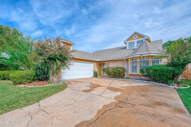 view of front of house with fence, a shingled roof, an attached garage, driveway, and brick siding