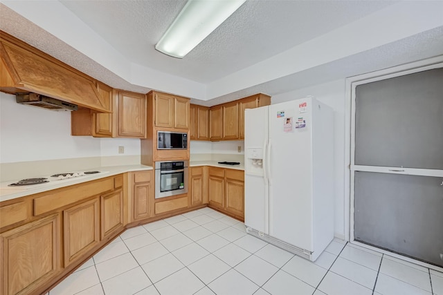 kitchen with light tile patterned flooring, a textured ceiling, white appliances, and light countertops