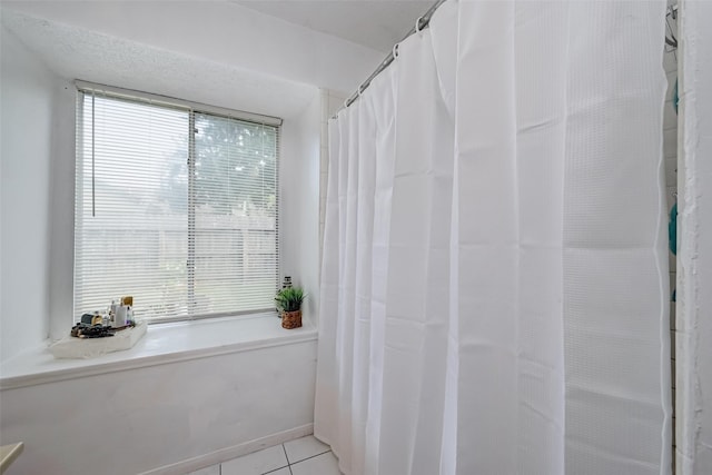 full bath featuring tile patterned flooring and a wealth of natural light