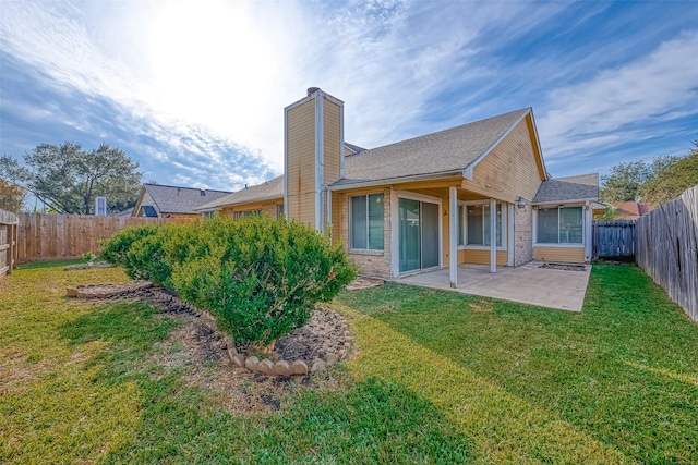 back of property featuring a chimney, a patio, a fenced backyard, and a lawn