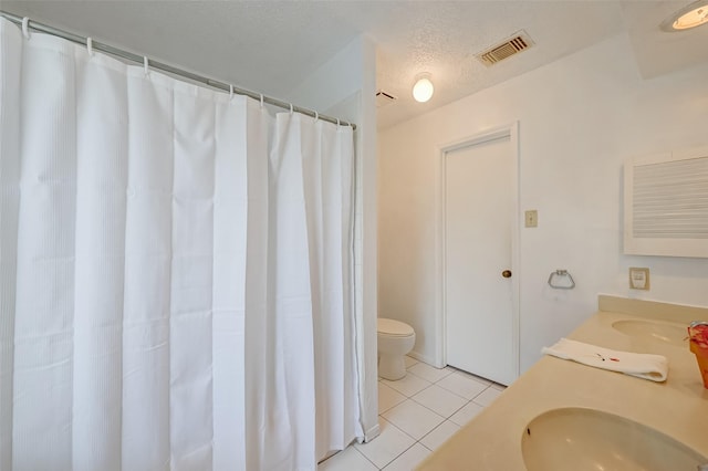 bathroom featuring a textured ceiling, vanity, toilet, tile patterned flooring, and visible vents