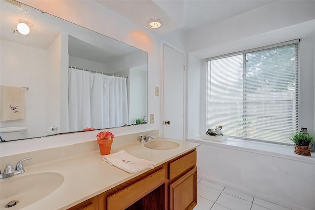 bathroom featuring a wealth of natural light, tile patterned flooring, and a sink