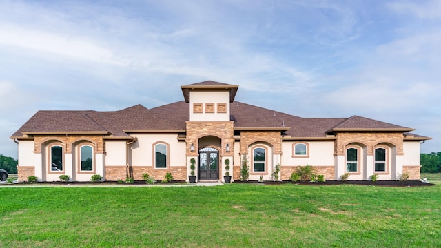 view of front of house featuring stone siding, a shingled roof, stucco siding, french doors, and a front lawn