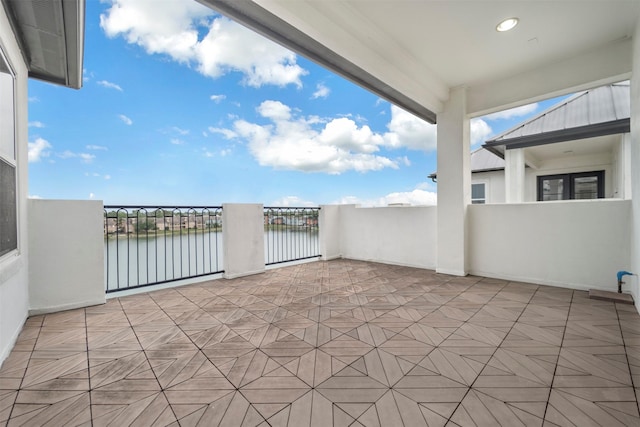 view of patio featuring a water view and a balcony