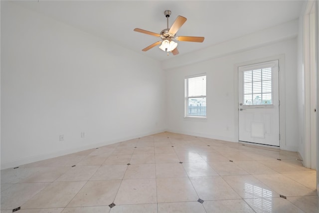 spare room with light tile patterned floors and a ceiling fan