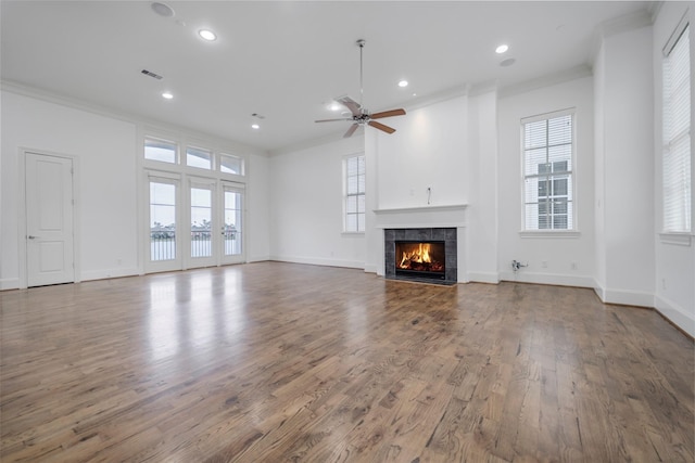 unfurnished living room with recessed lighting, ornamental molding, wood finished floors, and a fireplace