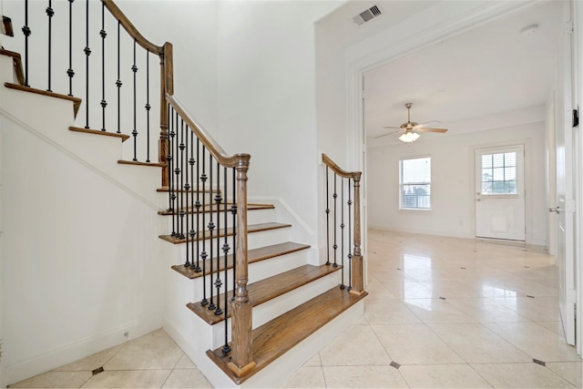 staircase with baseboards, ceiling fan, visible vents, and tile patterned floors