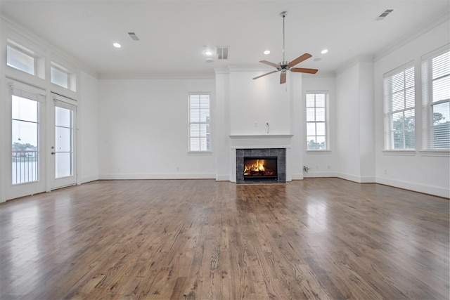 unfurnished living room featuring ceiling fan, ornamental molding, a tile fireplace, and visible vents