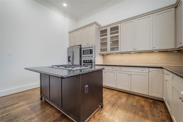 kitchen featuring crown molding, glass insert cabinets, tasteful backsplash, and stainless steel appliances