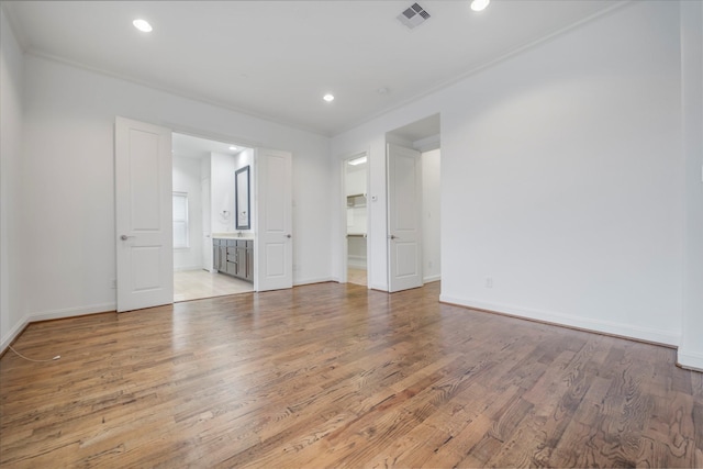 unfurnished bedroom with visible vents, recessed lighting, baseboards, and wood finished floors
