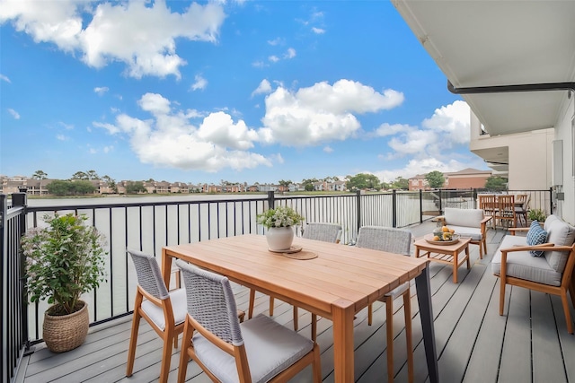balcony featuring a water view and an outdoor living space
