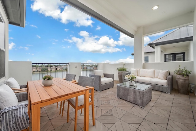 balcony with a water view, outdoor lounge area, and a patio area