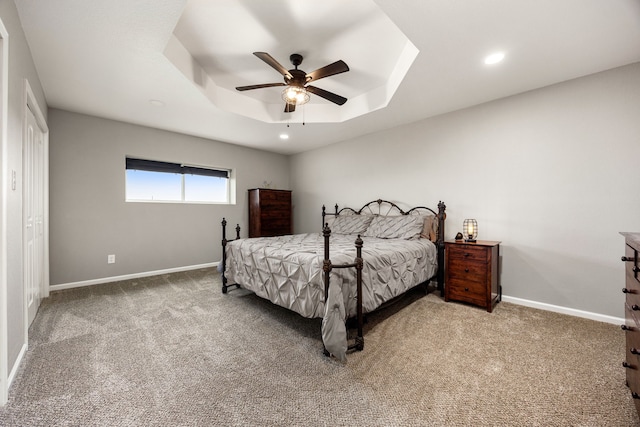 carpeted bedroom with recessed lighting, a raised ceiling, a ceiling fan, and baseboards