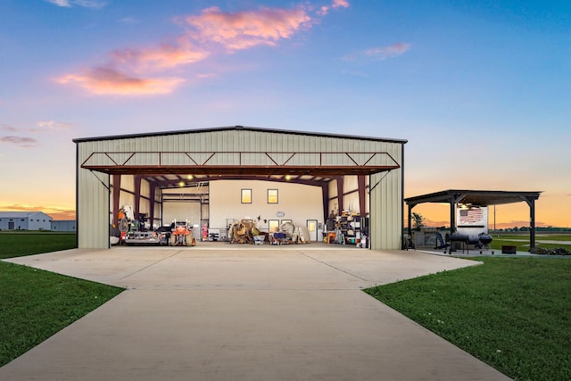 outdoor structure at dusk with a yard and driveway