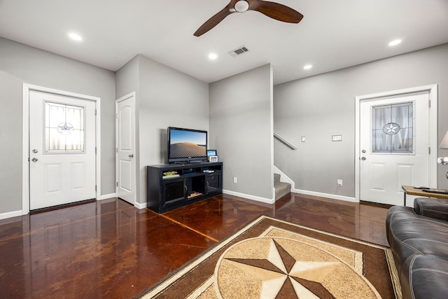 living area featuring stairway, visible vents, baseboards, and ceiling fan