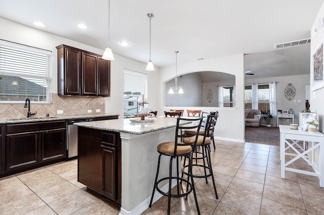 3901 Penny Ln, Deer Park, TX 77536 - kitchen with a sink, dishwasher, a breakfast bar, light tile patterned floors, and recessed lighting