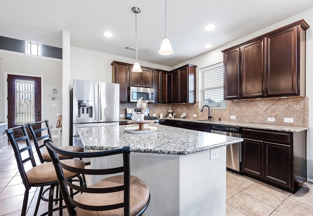 3901 Penny Ln, Deer Park, TX 77536 - kitchen with stainless steel appliances, dark brown cabinetry, light stone counters, light tile patterned flooring, and recessed lighting
