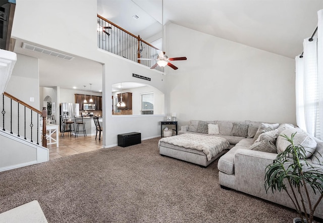 3901 Penny Ln, Deer Park, TX 77536 - carpeted living area featuring arched walkways, stairs, ceiling fan, baseboards, and high vaulted ceiling