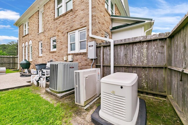 exterior details with a power unit, fence, and cooling unit
