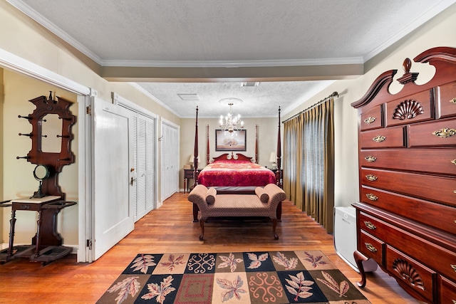 bedroom featuring ornamental molding, a chandelier, a textured ceiling, and light wood-type flooring