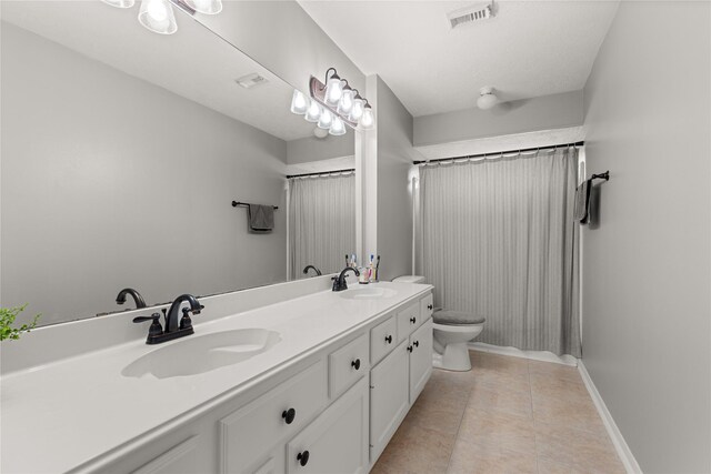 1509 Shamrock Ln, Deer Park, TX 77536 - full bath with toilet, double vanity, tile patterned flooring, and baseboards
