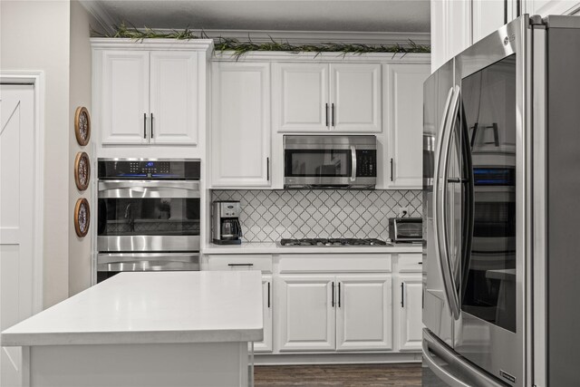 1509 Shamrock Ln, Deer Park, TX 77536 - kitchen featuring appliances with stainless steel finishes, white cabinetry, light countertops, crown molding, and backsplash