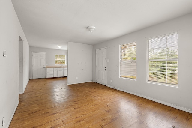empty room with baseboards and light wood-type flooring