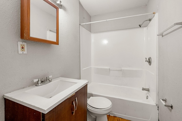 full bath with toilet,  shower combination, a textured wall, and vanity
